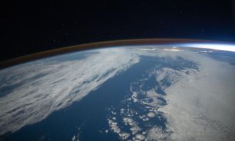 The airglow blankets the Earth's horizon during an orbital sunset in this photograph from the International Space Station as it orbited 262 miles above the Pacific Ocean southwest of California.