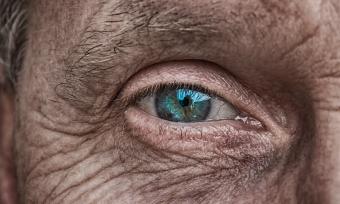 Close up photograph of an elederly man's blue eye.