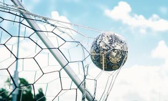 Photo of a soccer ball hitting the goal net.