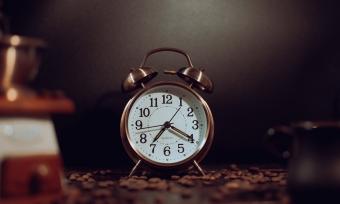 Photo of a clock surrounded by coffee beans