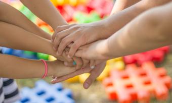 Photo of a group of people piling hands in a show of sportsmanship