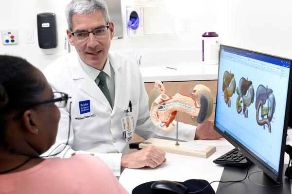 Doctor with patient looking at computer monitor with pancreas images