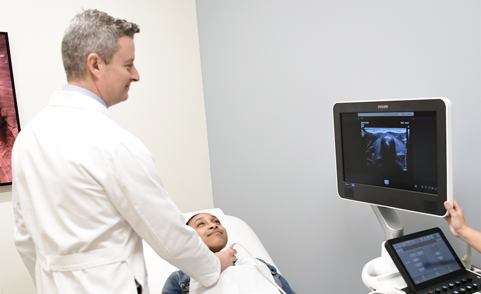 Dr. Grogan performing an ultrasound on a patient's throat.