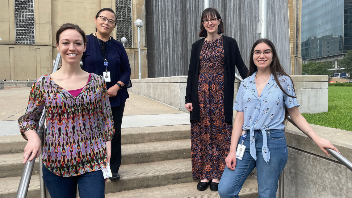 Members of the Lindsay Burrage lab stand outside on a set of stairs.