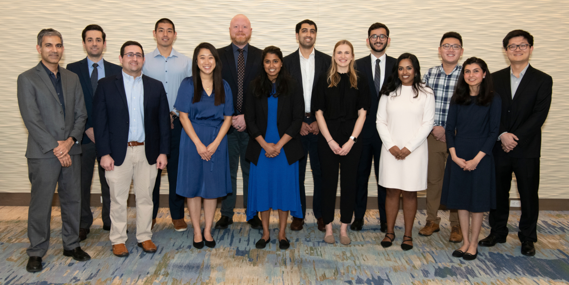 A group of residents and fellows pose against a wall