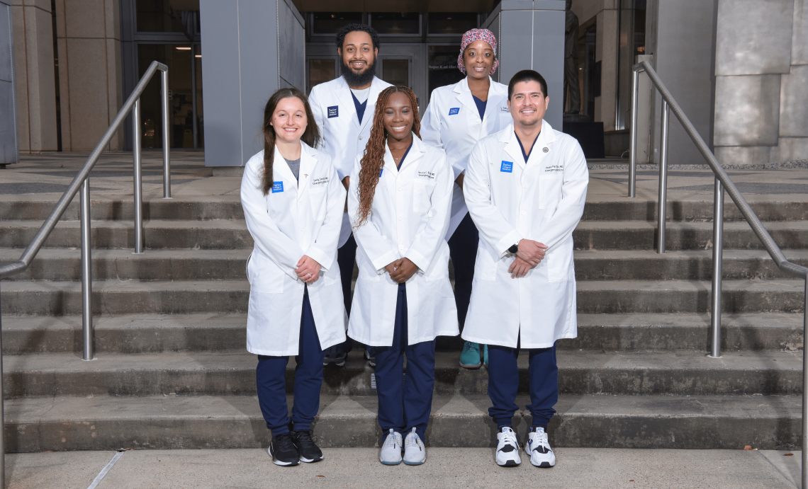 Five chief residents in white coats posed together