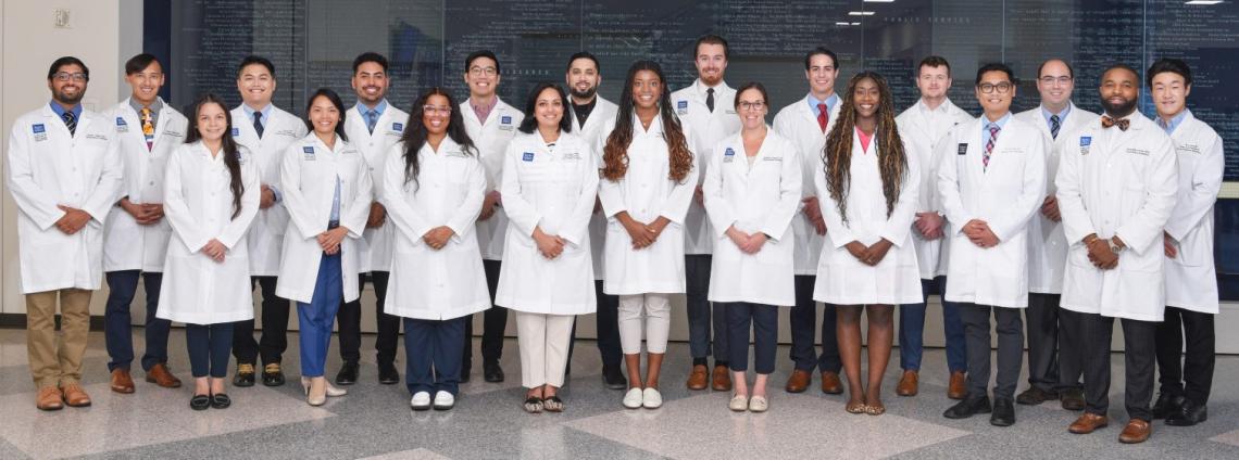 A group wearing white coats, lined up 