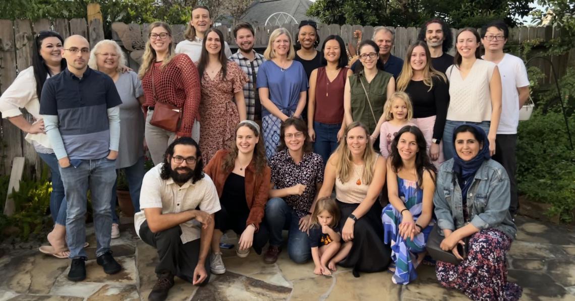 A large group of people posing in a backyard