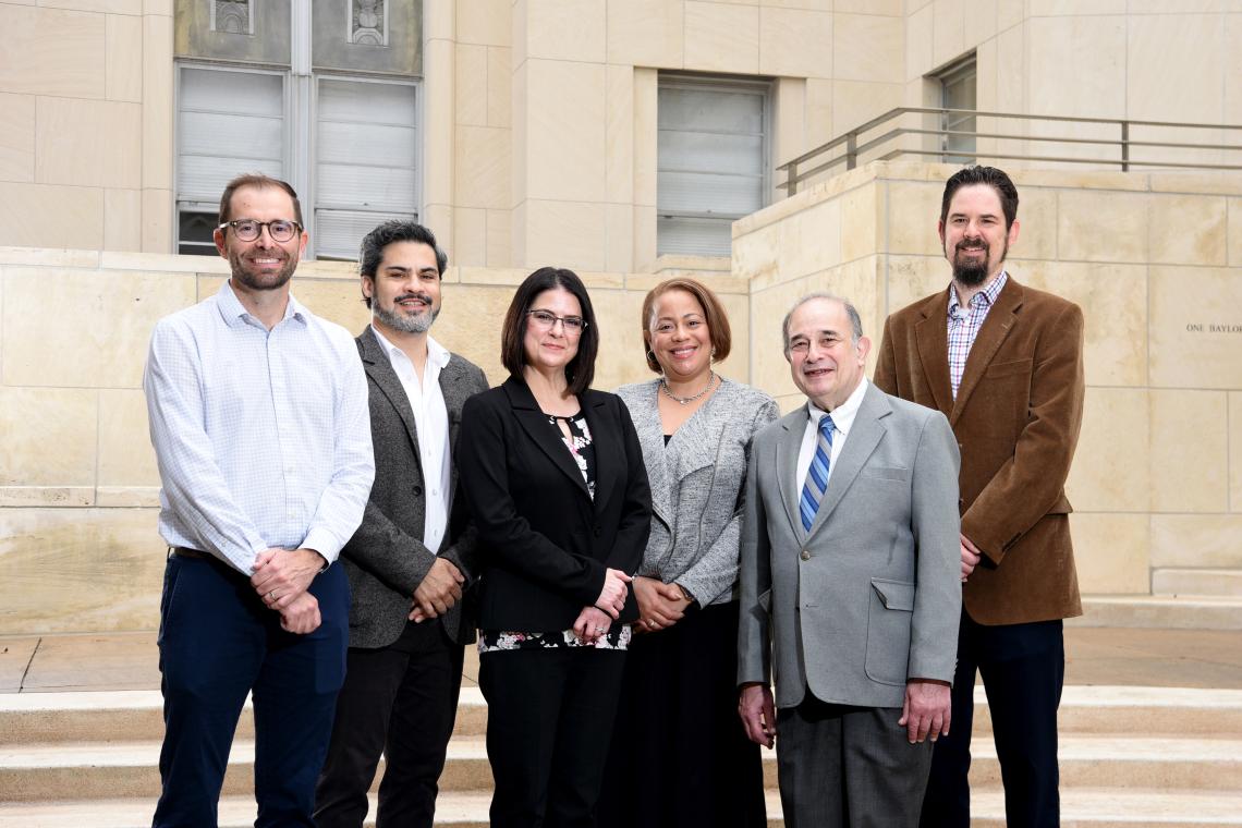 6 people standing in front of a building smiling