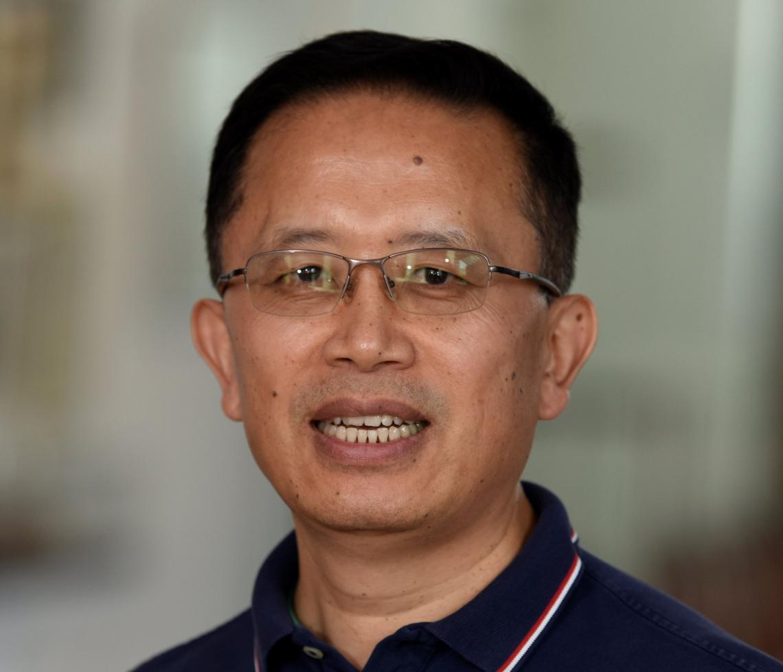 man smiling in front of grey background