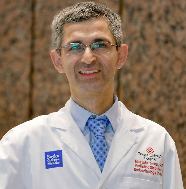 man smiling in front of a brown wall