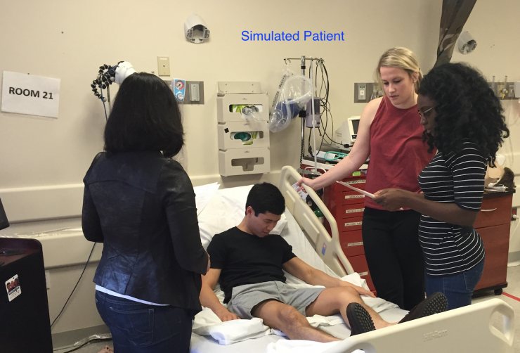 Internal Medicine residents participating in a simulation exercise at the bedside.