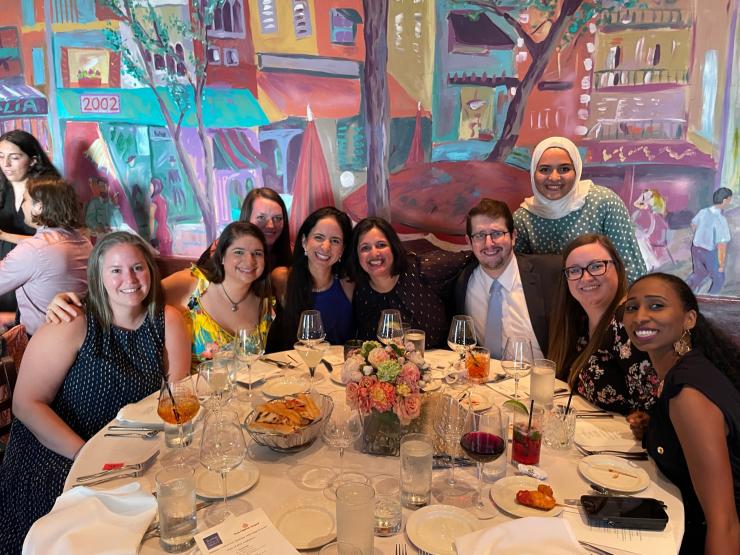 Pediatric Critical Care Fellowship members at dinner, posing while sitting at a table.