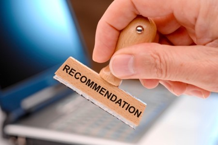 A person holding a stamp with the words "recommendation" on it.