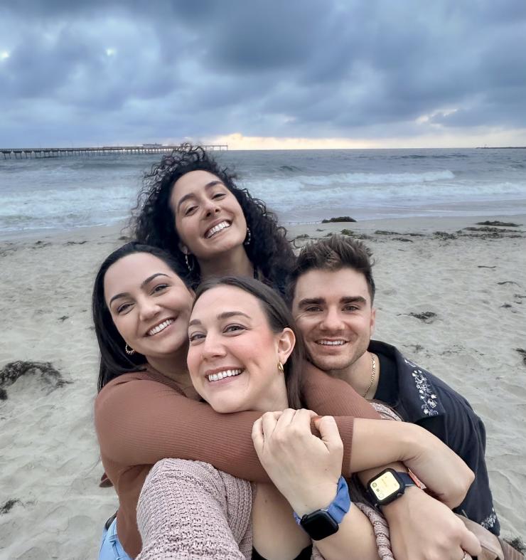 4 people smiling at the beach