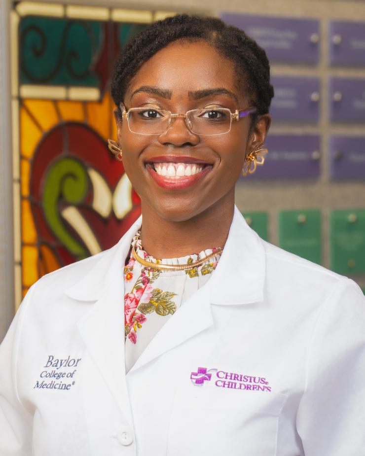 woman with her hair up and clear glasses on smiling