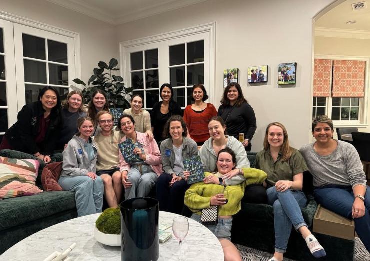 group of people in a house sitting on couches smiling