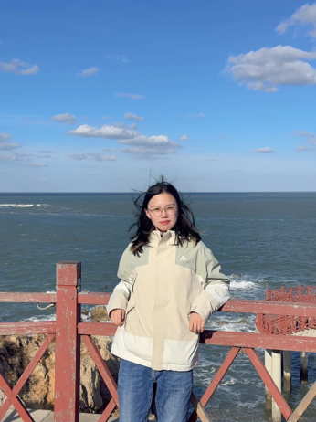 woman leaning on a safety rail in front of a body of water