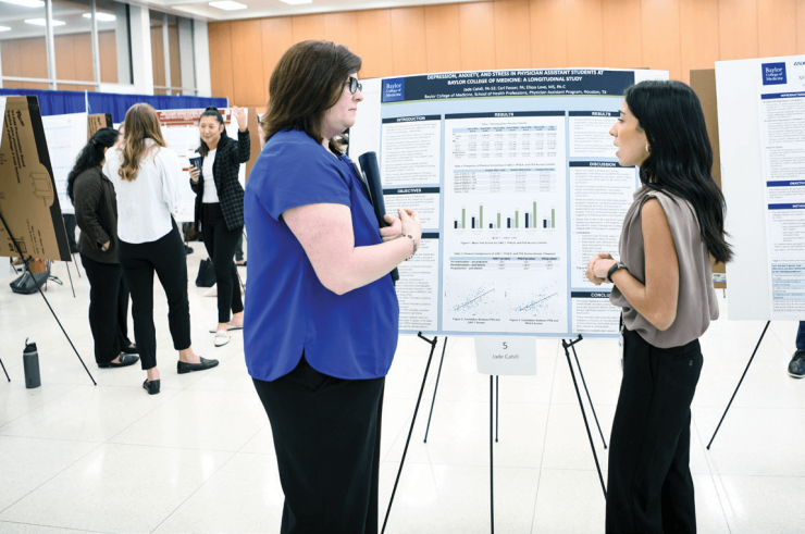 Two people looking at a poster presentation