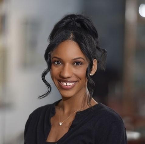 Woman smiling in front of grey background