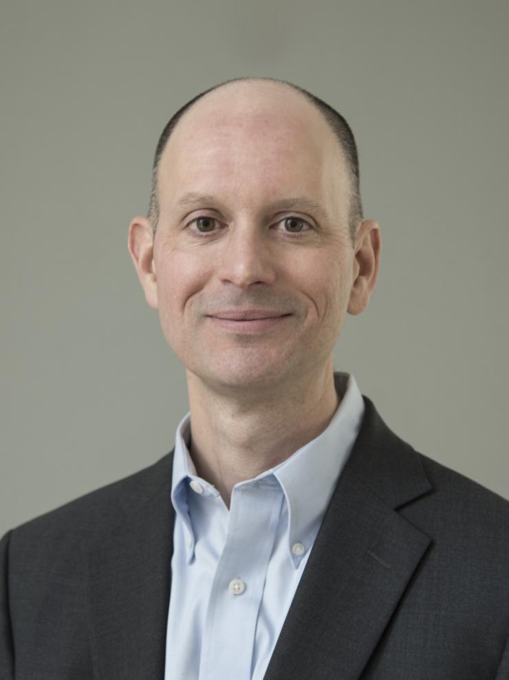 man smiling in front of grey background