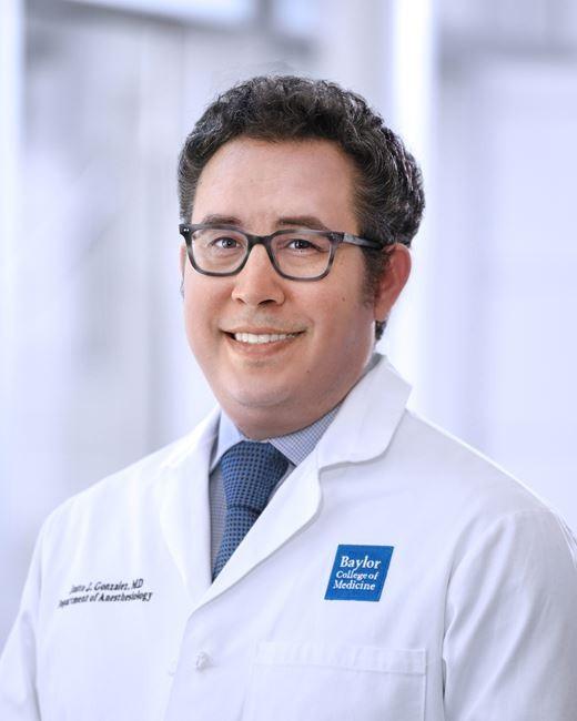 man with short dark hair and glasses on smiling