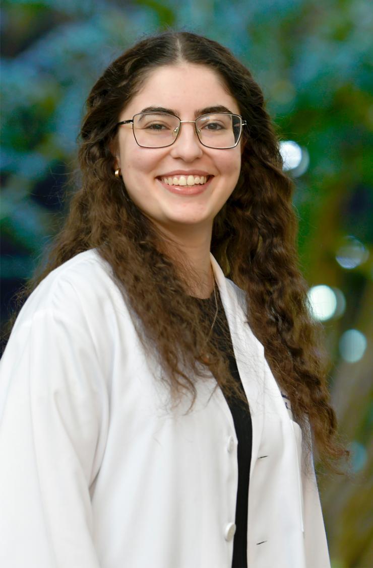 woman with long curly hair and glasses on smiling