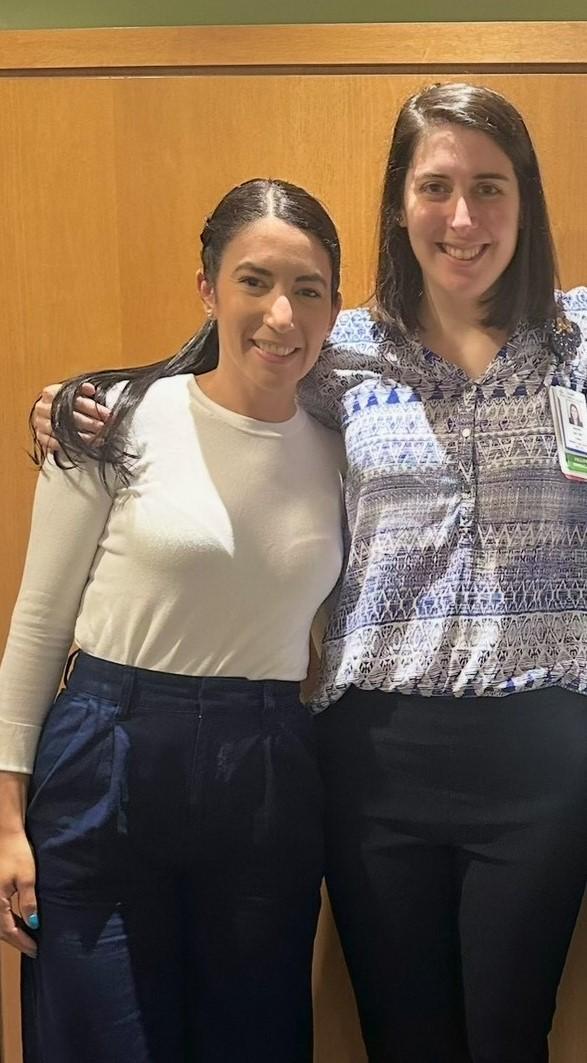 two women standing side by side and smiling