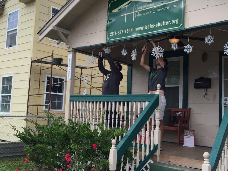 Volunteers hanging Christmas light at the Bay Area Homeless Services Inc.
