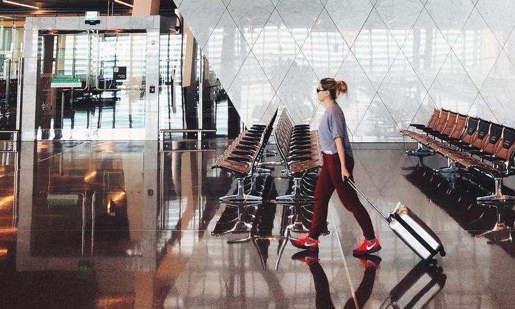 A person walks through an airport on the way to a holiday destination