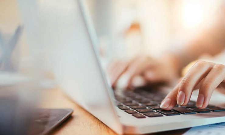 A person typing at a laptop