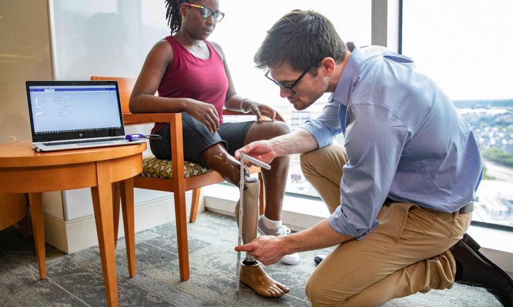 Doctor fitting patient with prosthetic leg