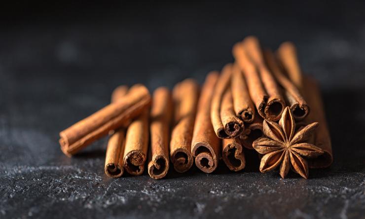 Stack of cinnamon sticks and star anice spice on a black background
