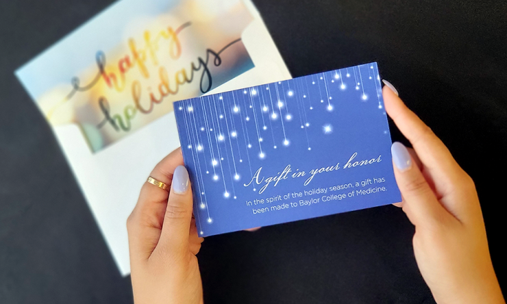 Hands holding a blue holiday card