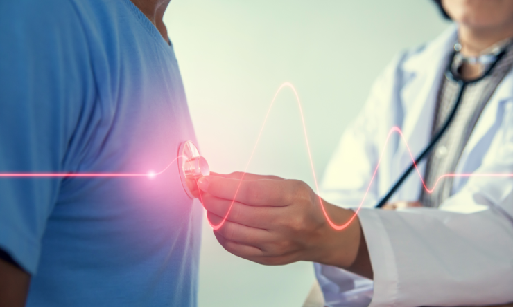 医生用听诊器听病人的心脏,心跳显示的图形图像与红线。