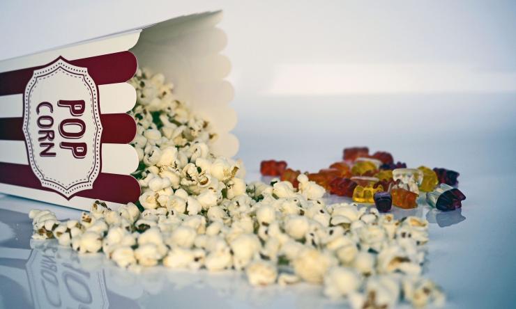 Photo of popcorn and gummie bears to represent movie snacks.