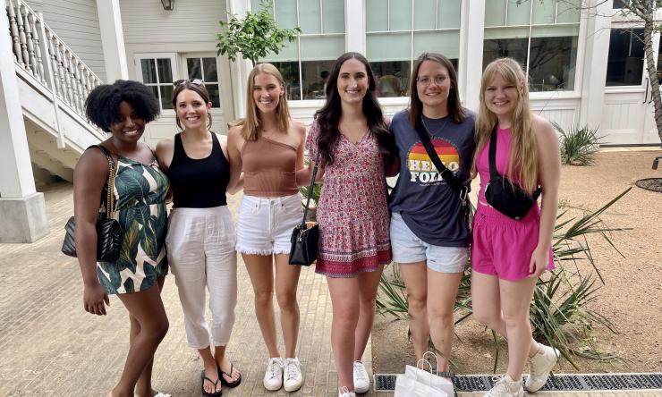 Six residents in a group picture in a courtyard