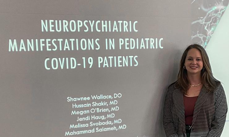 Dr. Shawnee Wallace next to a projection that reads Neuropsychiatric Manifestations in Pediatric COVID-19 Patients