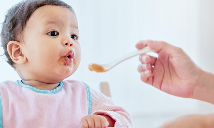 Photo of Feeding baby girl with a spoon