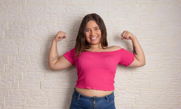 Young teenage girl showing flexed arms