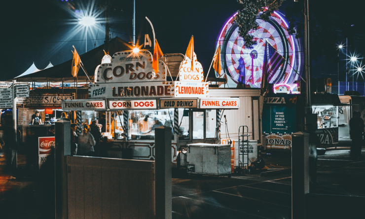 Photo taken at night of a corn dog stand at a rodeo.