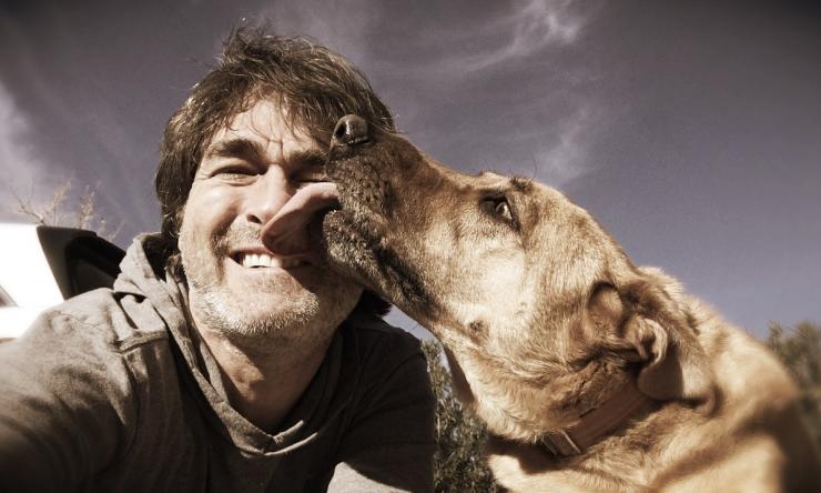 Photo of a dog licking a man's face