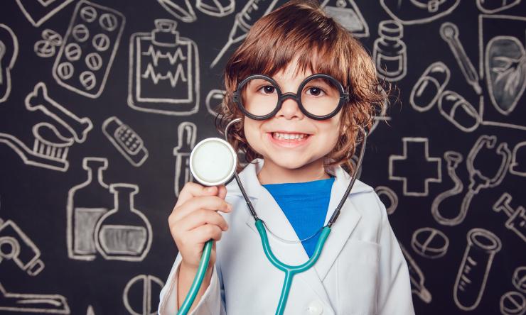 toddler in doctor attire holding a stethescope