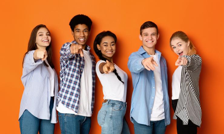 diverse group of pointing smiling and pointing at camera