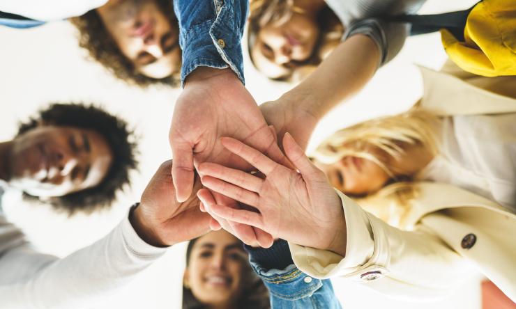 a group of people put their hands together in a pile