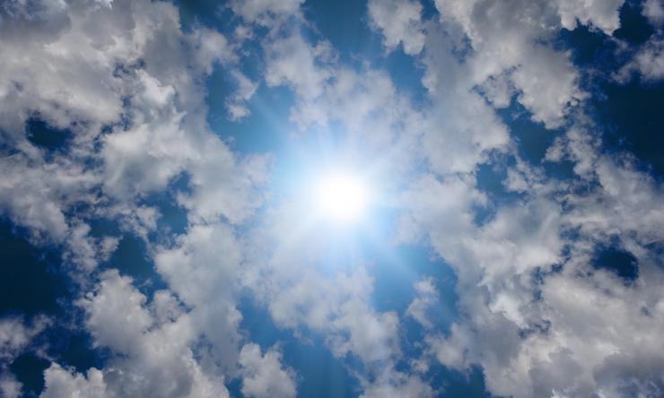 Photo of the sky showing the sun and clouds