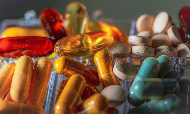 A close up photo of pills, vitamins and medications in multiple colors. 