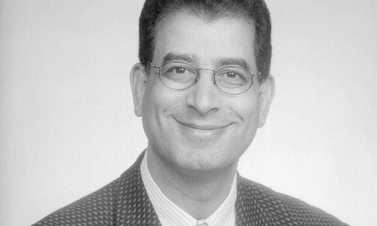 Man smiling in front of grey background