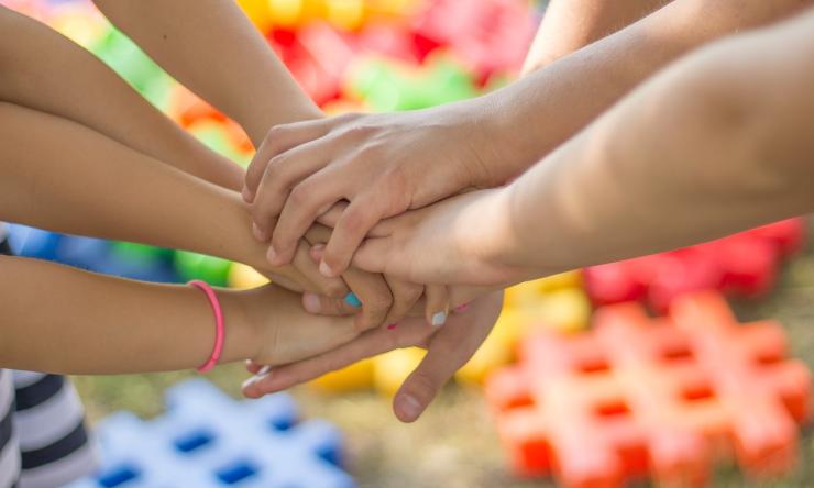 Photo of a group of people piling hands in a show of sportsmanship