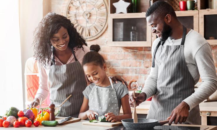 Young girl cooking with parents
